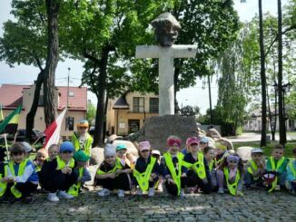 grupowe zdjęcie przedszkolaków pod pomnikiem AK