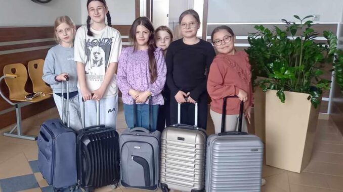 grupa dziewcząt z walizkami zamiast plecaków