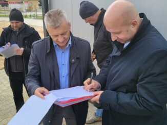 Zastępca Burmistrza Krzysztof Dąbrowski składa podpis na protokole odbioru.