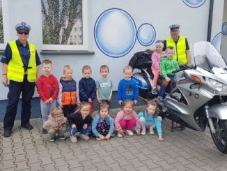 policja z motocyklem z wizytą u przedszkolaków