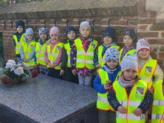 przedszkolaki stoją przy grobie