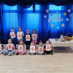 Dzieci na scenie, trzymające kartony z literami, układającymi się w napis "GÓRA GROSZA"