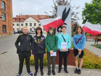 grupa młodzieży (pięciu chłopców) pod Pomnikiem Cichociemnych w Parku Przemysłowym "Sokołów"