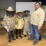 Dzieci przebrane w strojach pszczelarza z panem Mariszem