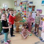 Dzieci podczas malowania farbkami makiety dinozaura