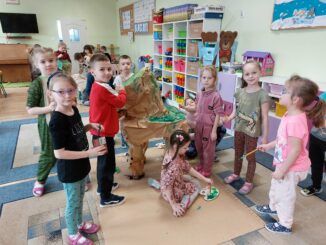 Dzieci podczas malowania farbkami makiety dinozaura
