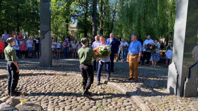 delegacja samorządu miejskiego składa kwiaty pod Pomnikiem Czynu Niepodległościowego