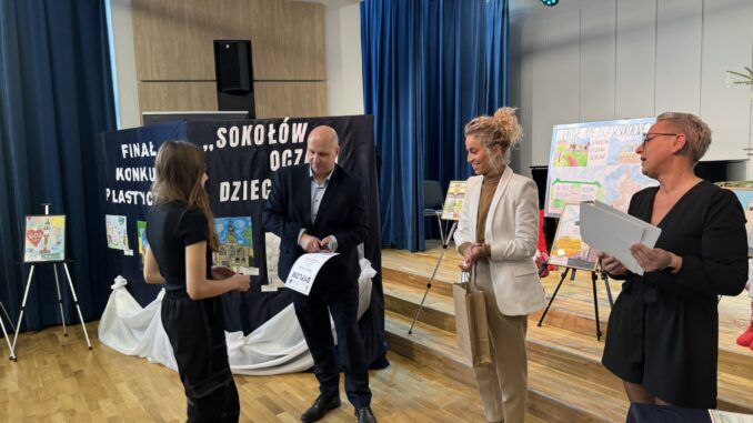 Naczelnik Wydziału Oświaty Ewelina Śmiejkowska i Zastępca Burmistrza Krzysztof Dąbrowski wręczają nagrodę laureatce.