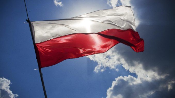 Flaga Polski na tle słonecznego nieba