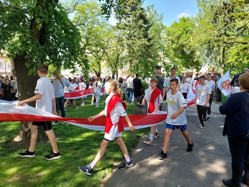 uczestnicy Sztafety Niepodległości podczas przemarszu z biało-czerwoną flagą na Skwerze Księdza Brzóski