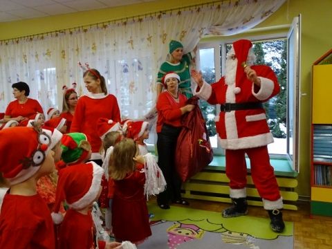 Święty Mikołaj wchodzi do przedszkola przez otwarte okno.