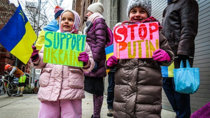 Dzieci z transparentami protestującymi przeciwko wojnie w Ukrainie