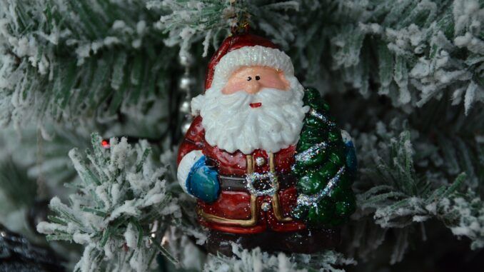 Bombka w kształcie św. Mikołaja na ośnieżonej choince