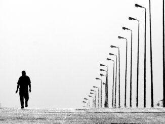 rząd latarni ulicznych i samotny człowiek - grafika ilustracyjna